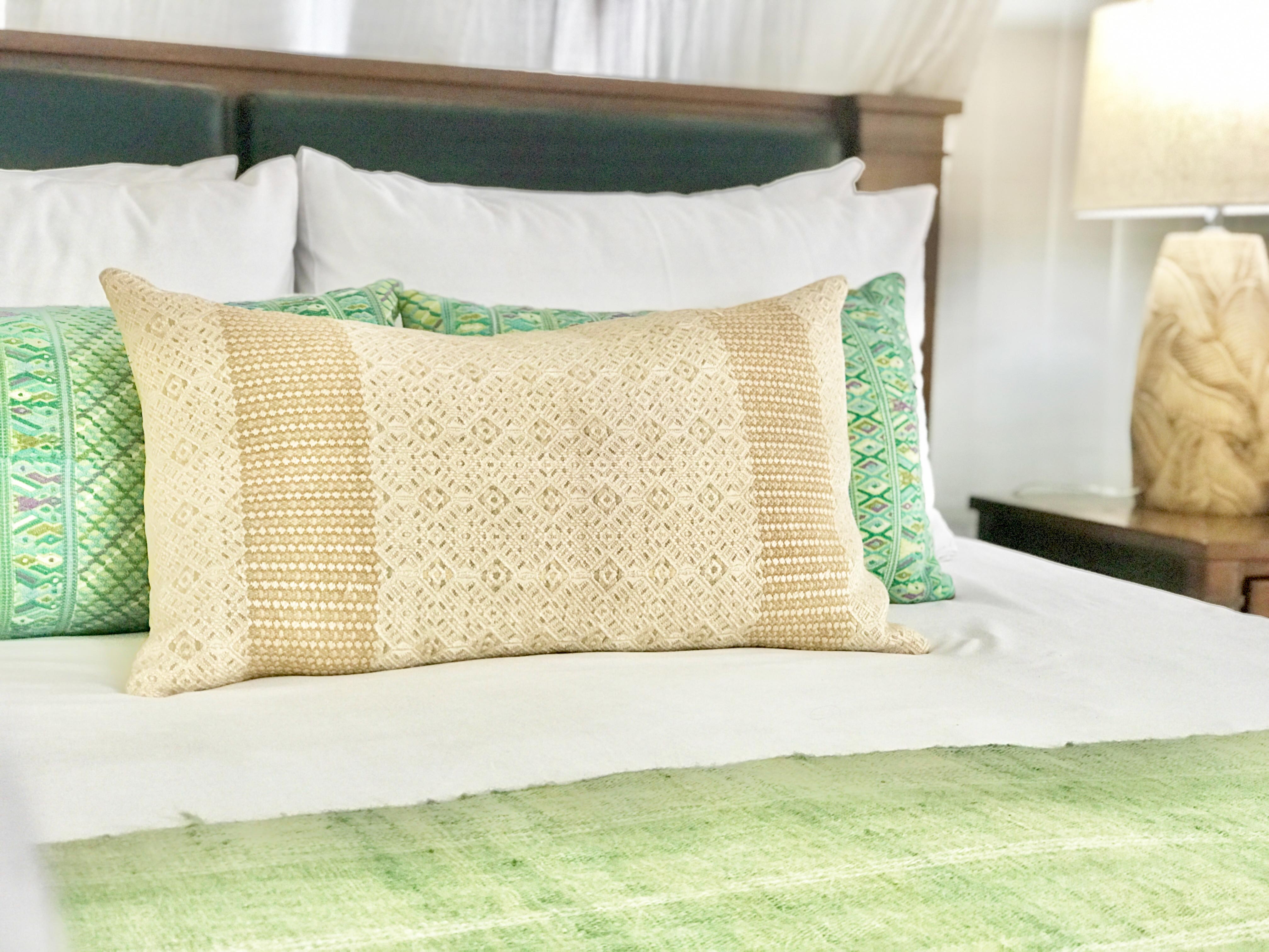 Embroidered textile cushions made from a Guatemalan huipil and corte.