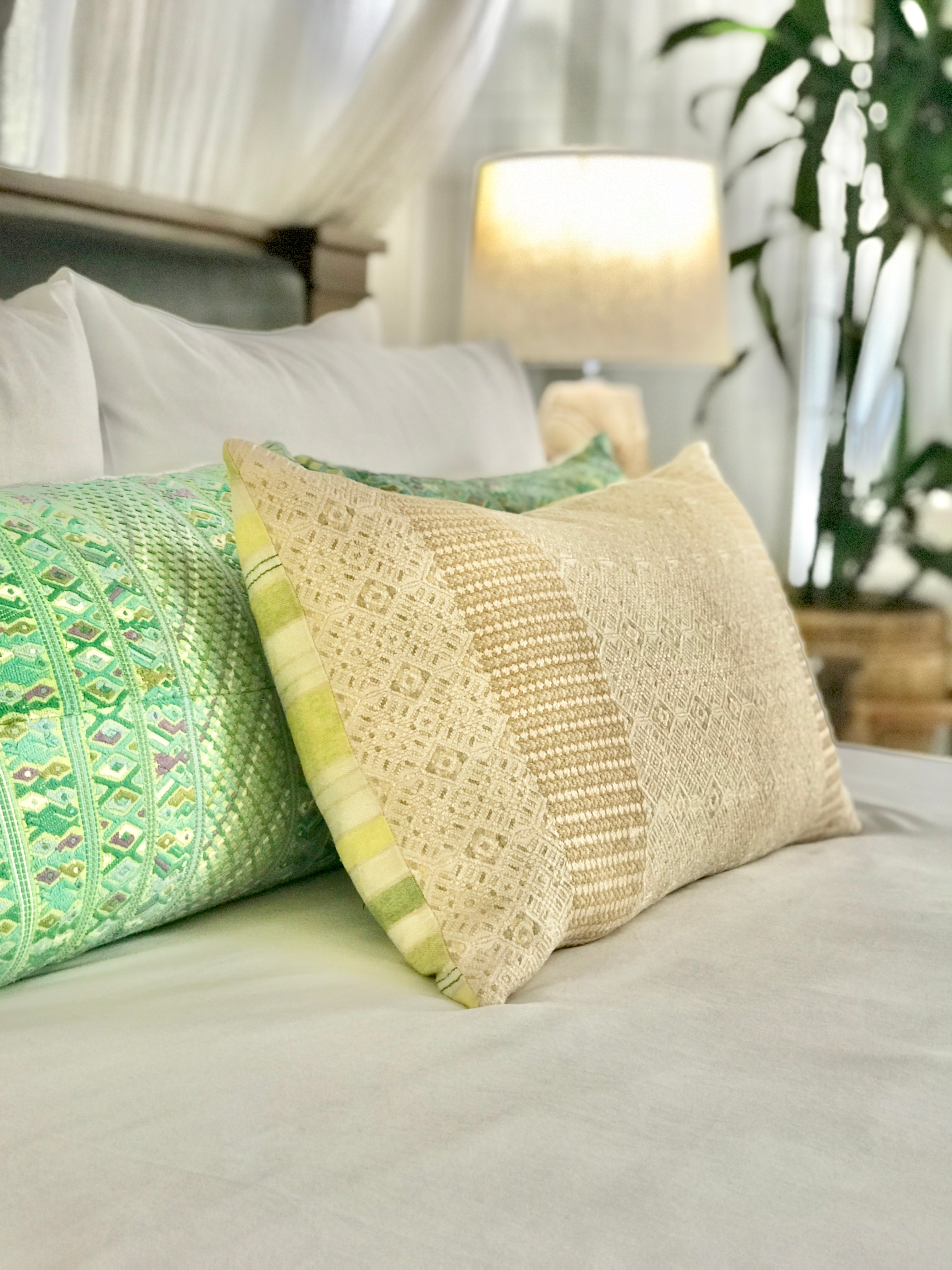 Embroidered textile cushions made from a Guatemalan huipil and corte.