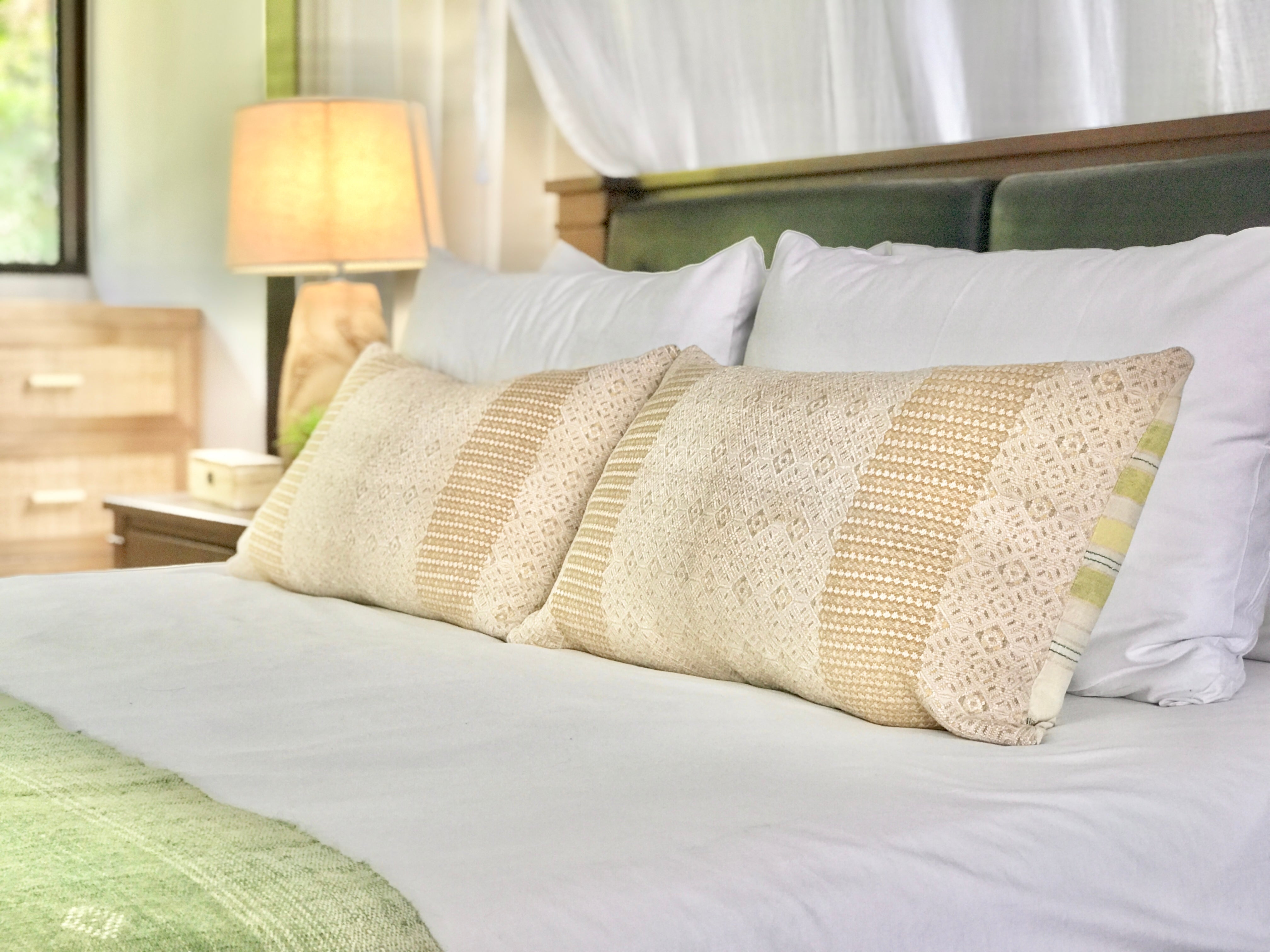 Embroidered textile cushions made from a Guatemalan huipil and corte.