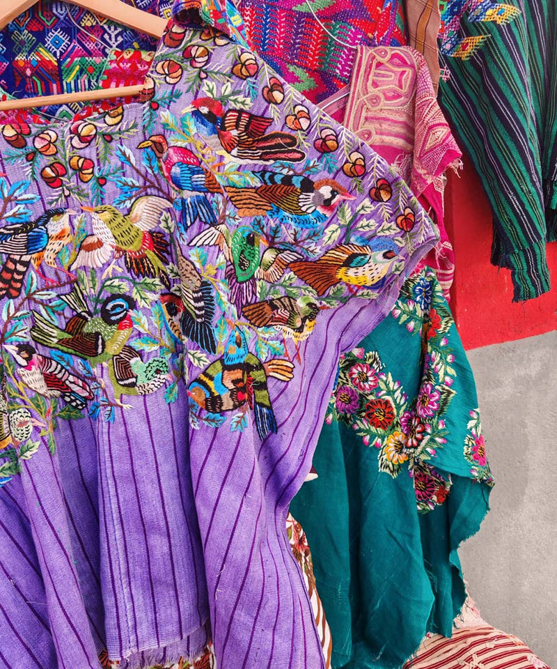 Huipil morado de Santiago con pájaros coloridos