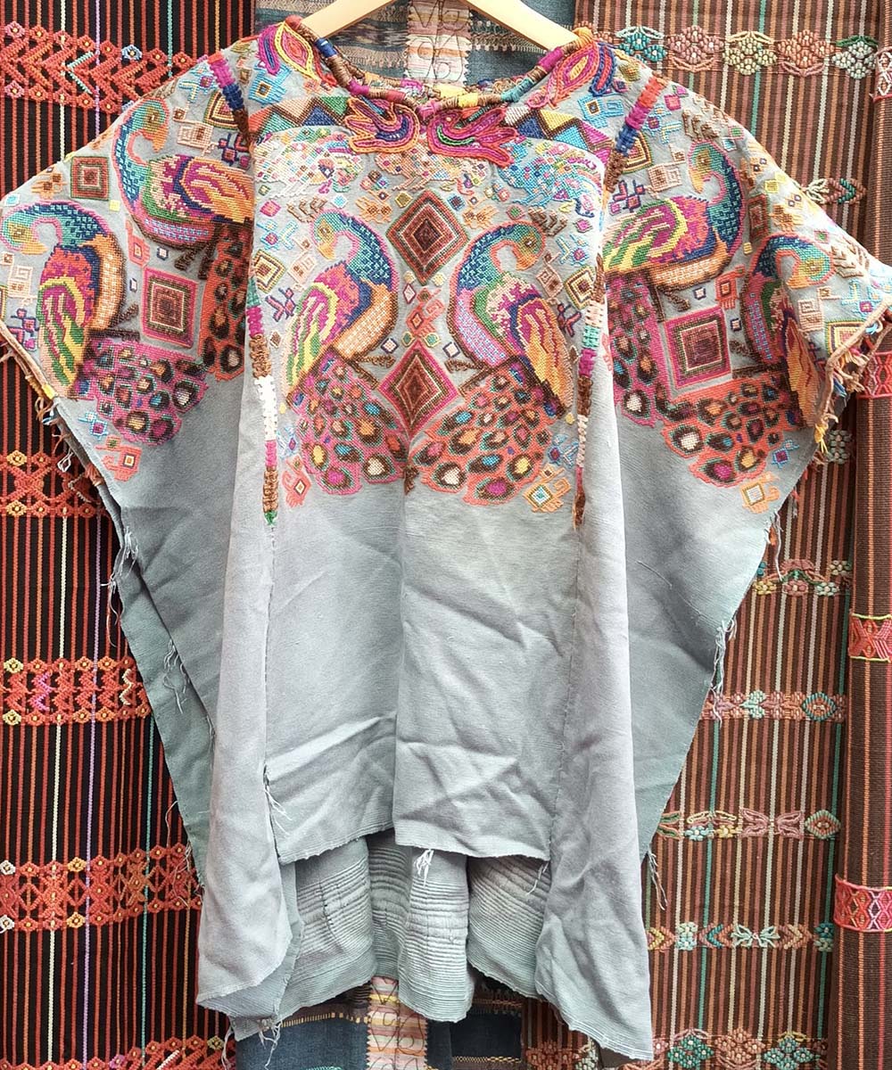 Pale blue Chichi huipil with peacocks