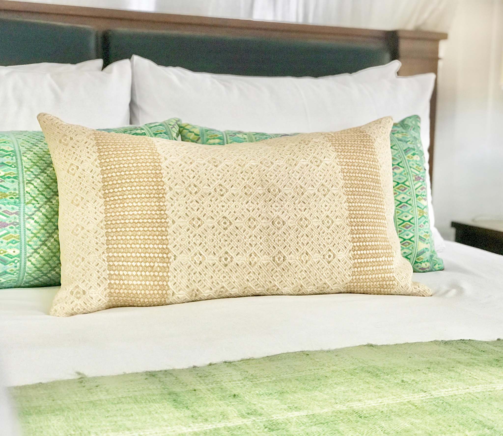 Embroidered textile cushions made from a Guatemalan huipil and corte.