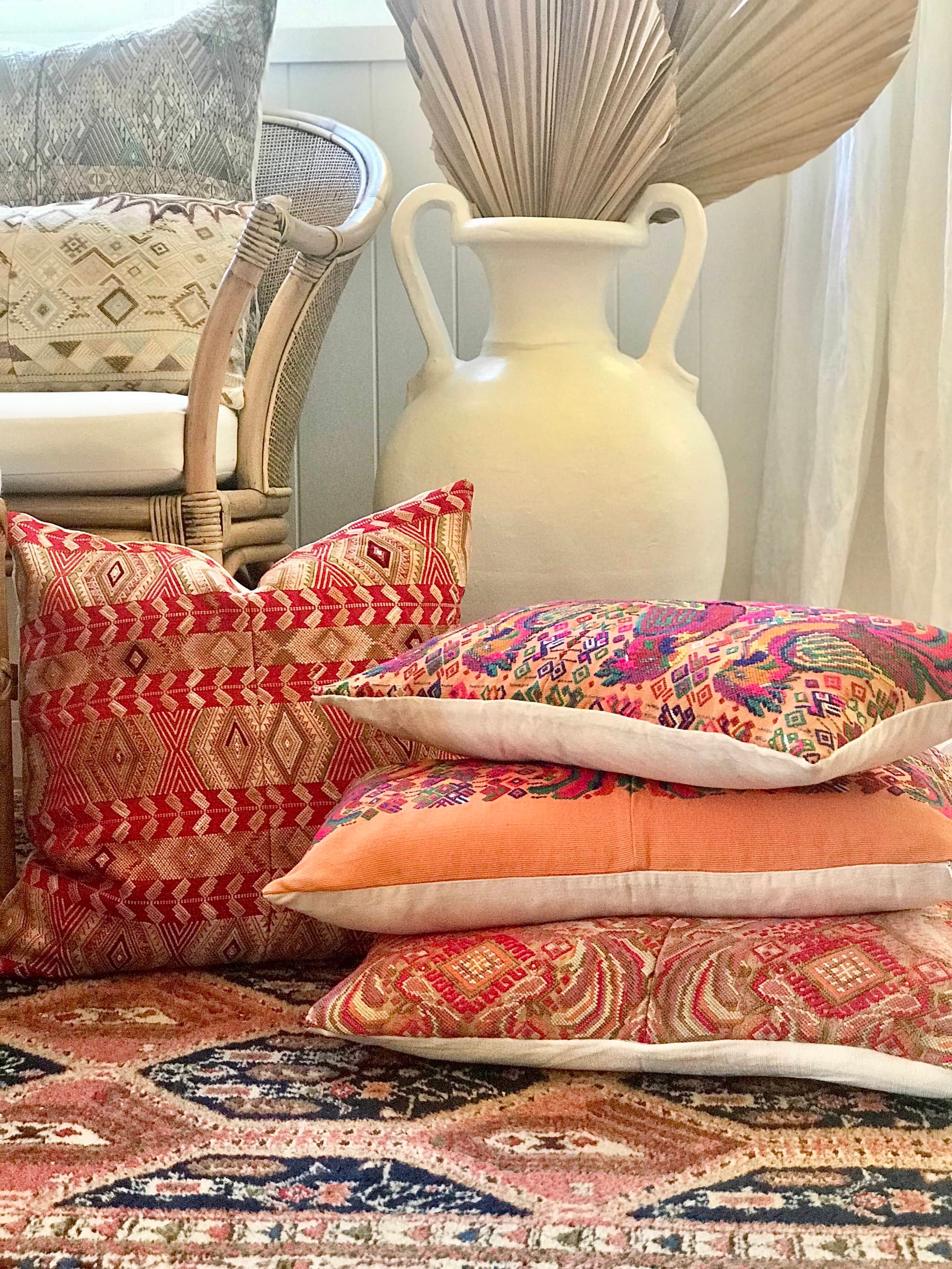 Guatemalan embroidered huipil pillow. Maximalist design of colourful parrots on orange cotton background