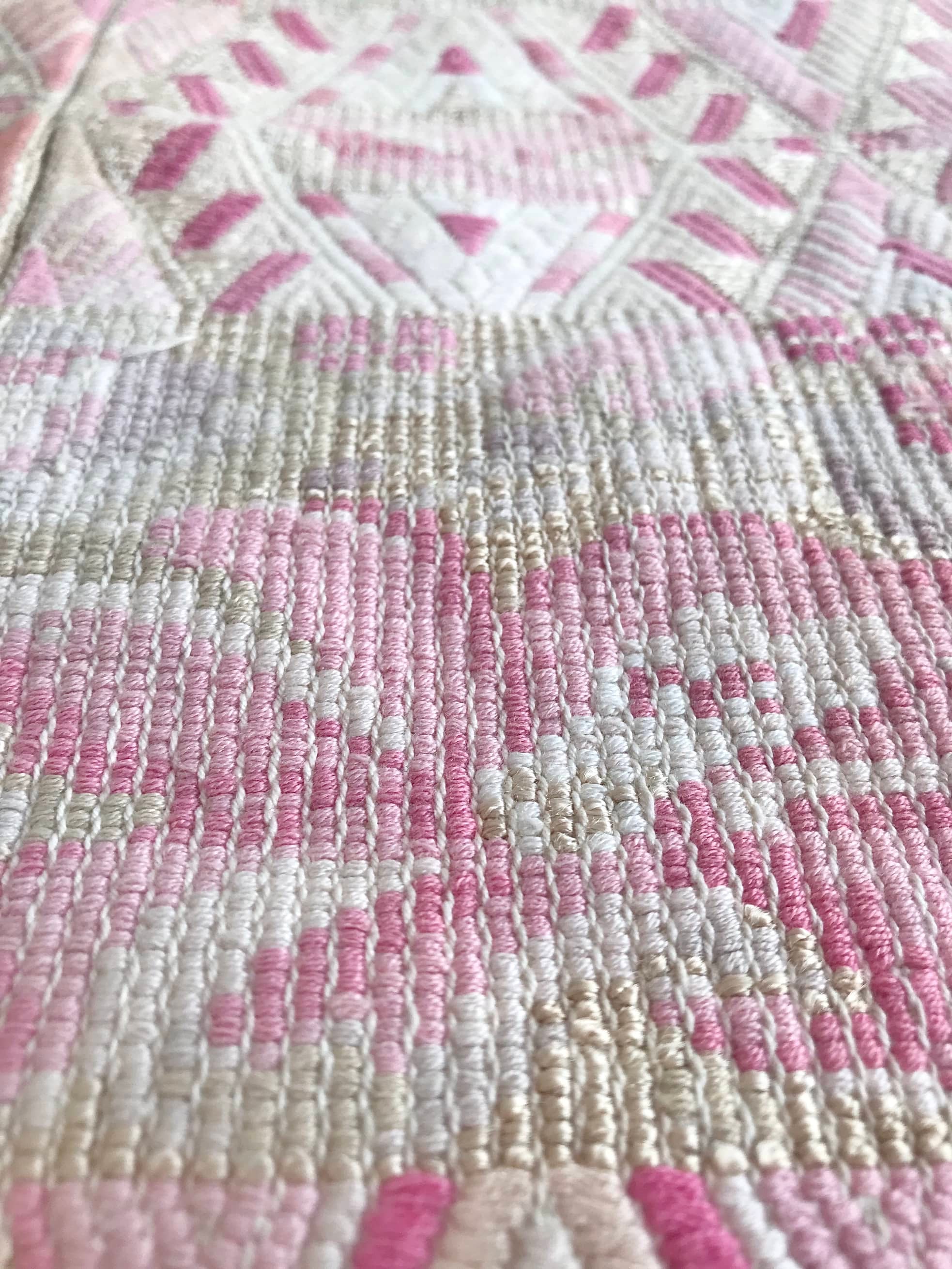 Guatemalan embroidered huipil pillow. Abstract flowers in a pale pink and white palette.