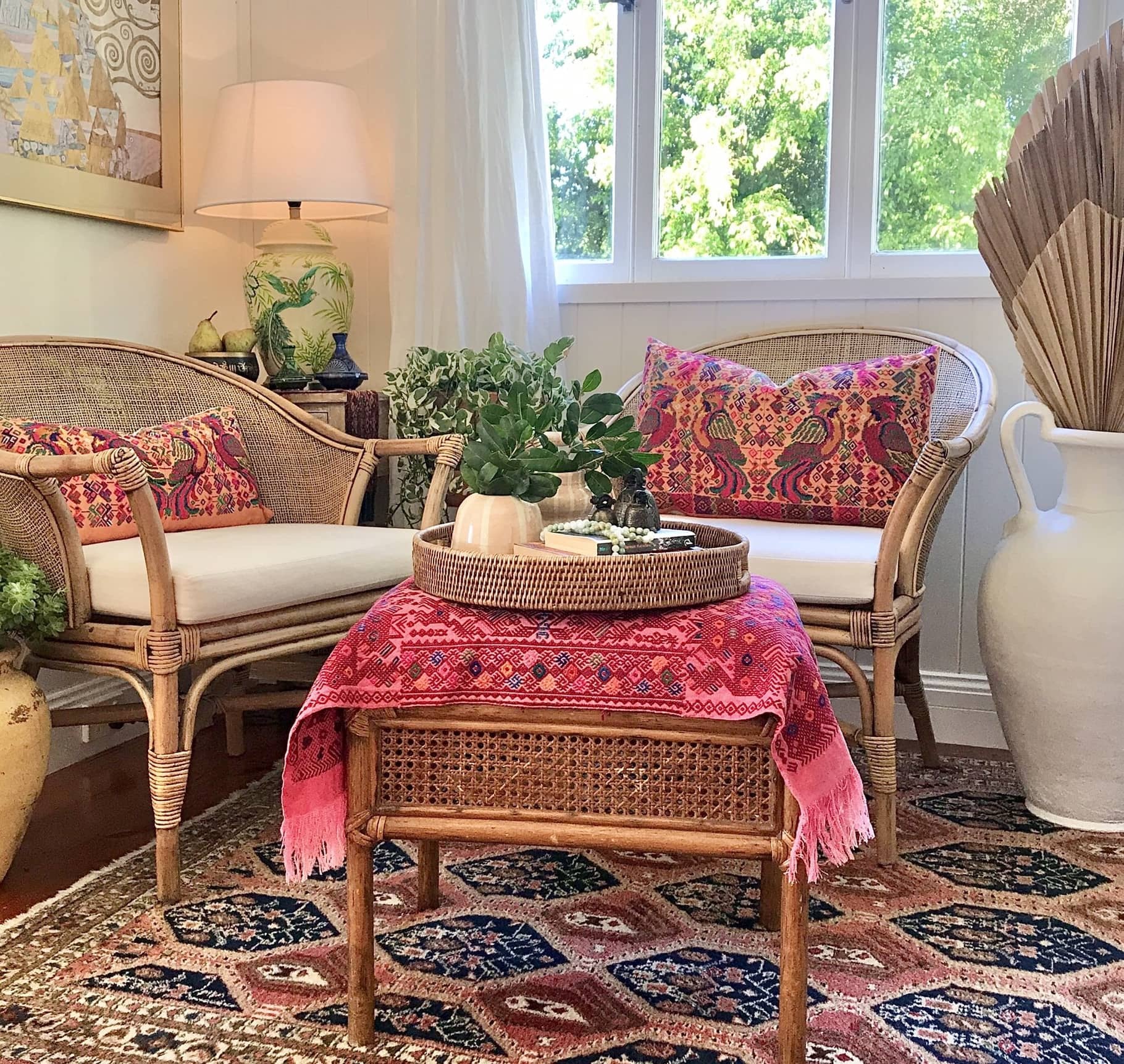 Guatemalan embroidered huipil pillow. Maximalist design of colourful parrots on orange cotton background