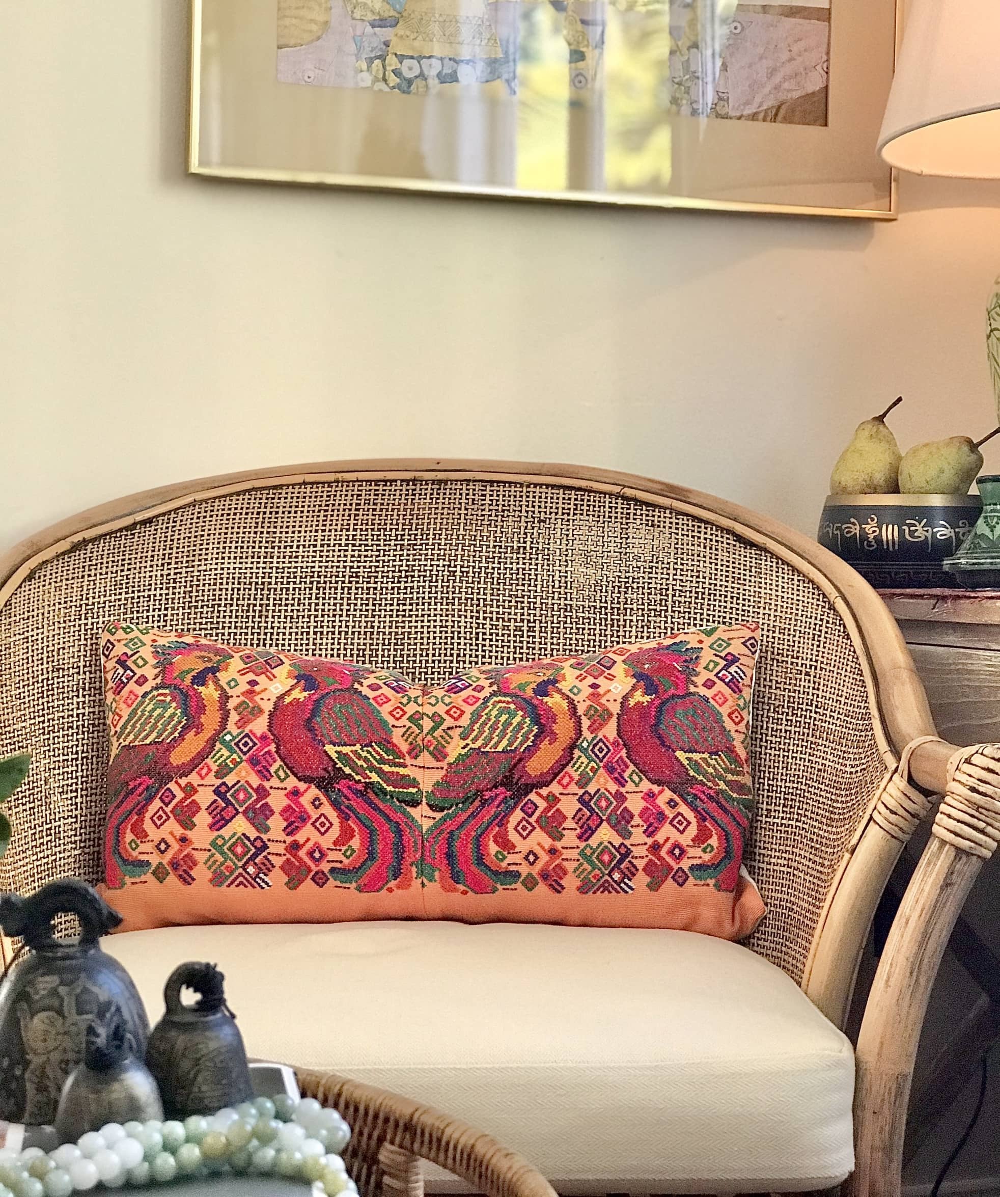 Guatemalan embroidered huipil pillow. Maximalist design of colourful parrots on orange cotton background