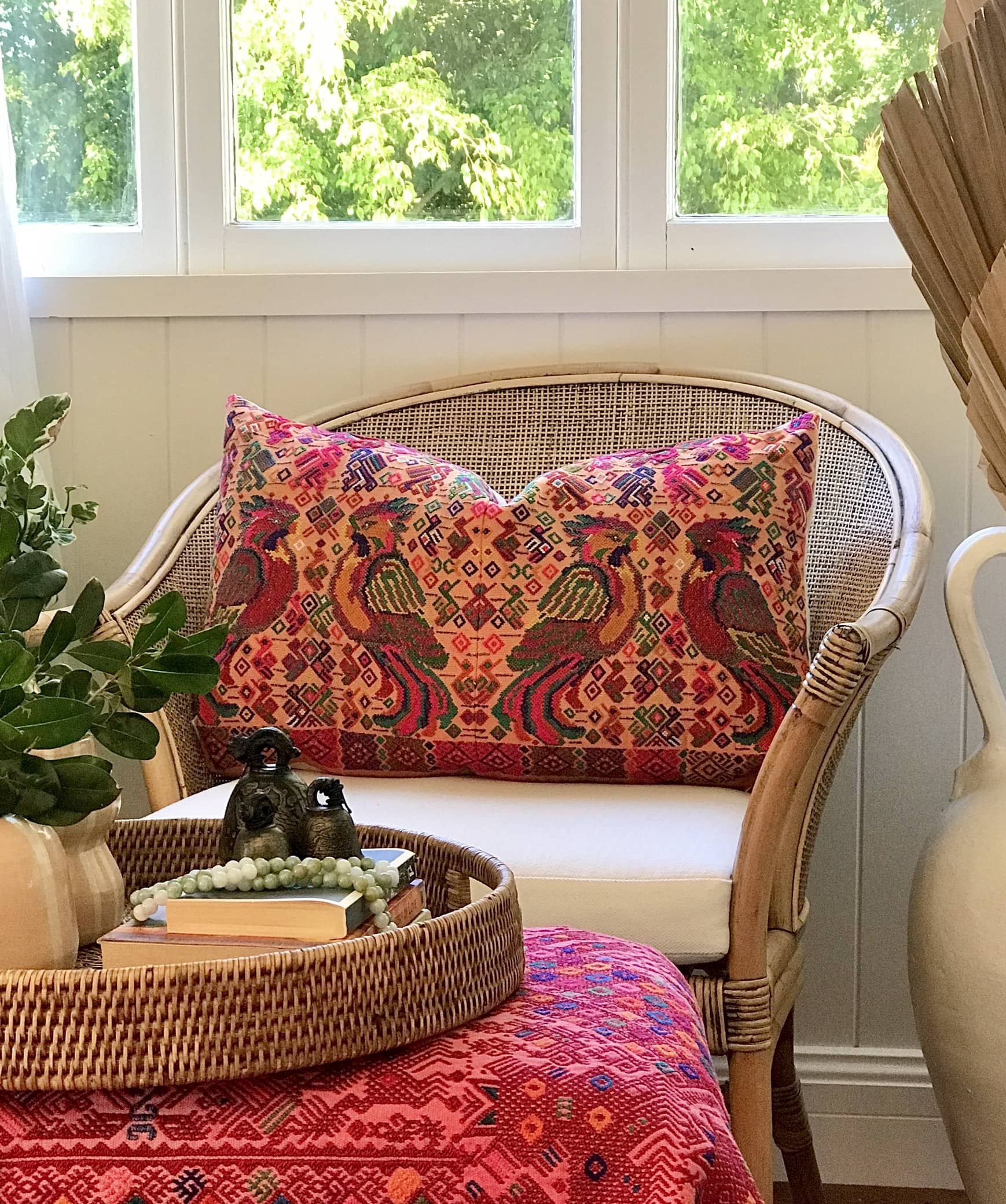 Guatemalan embroidered huipil pillow. Maximalist design of colourful parrots on orange cotton background