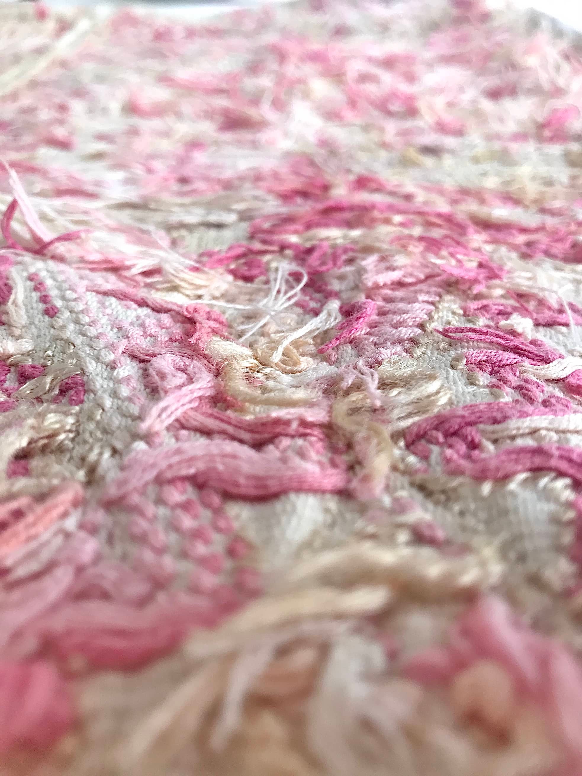 Guatemalan embroidered huipil pillow. Abstract flowers in a pale pink and white palette.