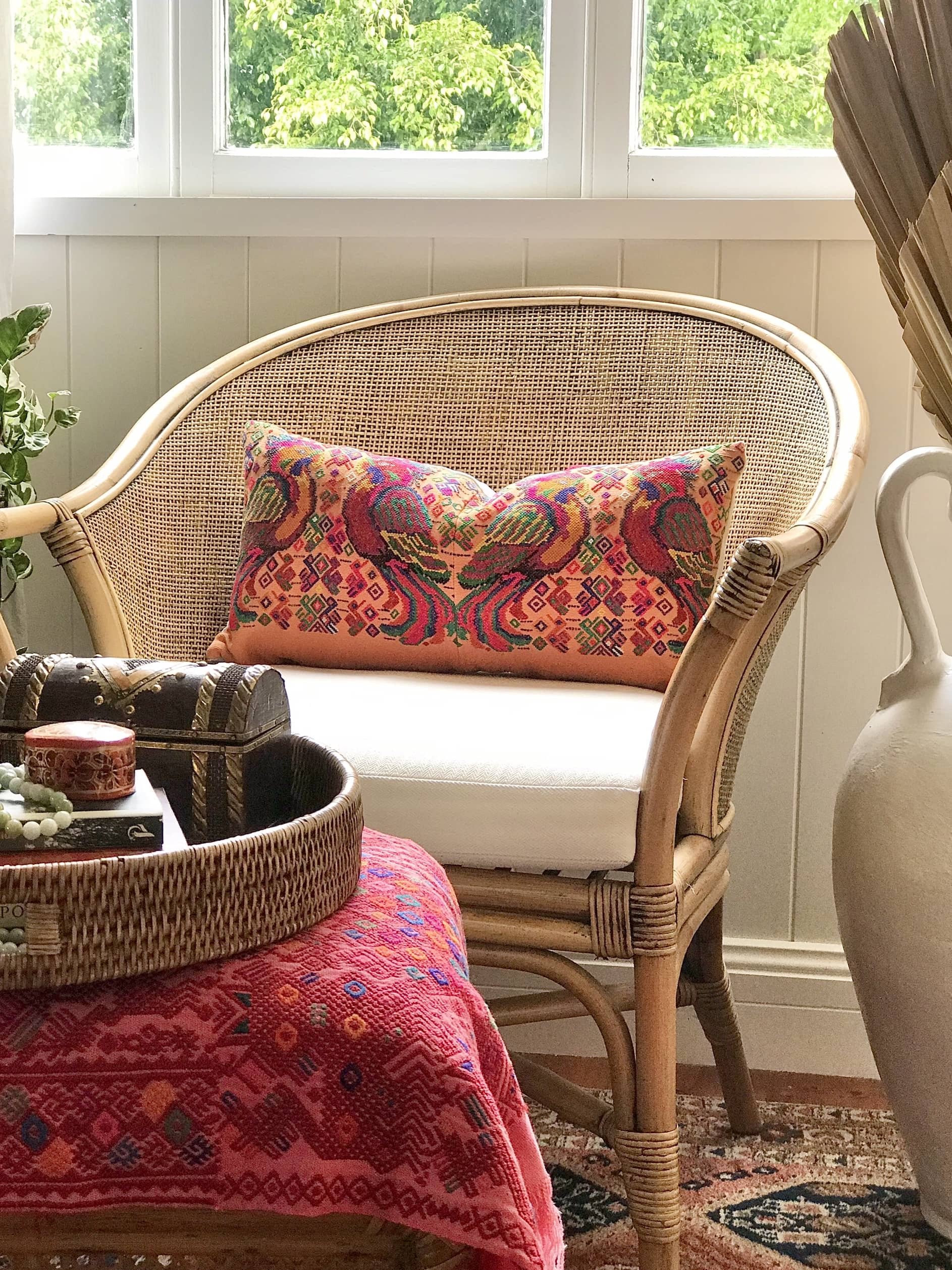 Guatemalan embroidered huipil pillow. Maximalist design of colourful parrots on orange cotton background