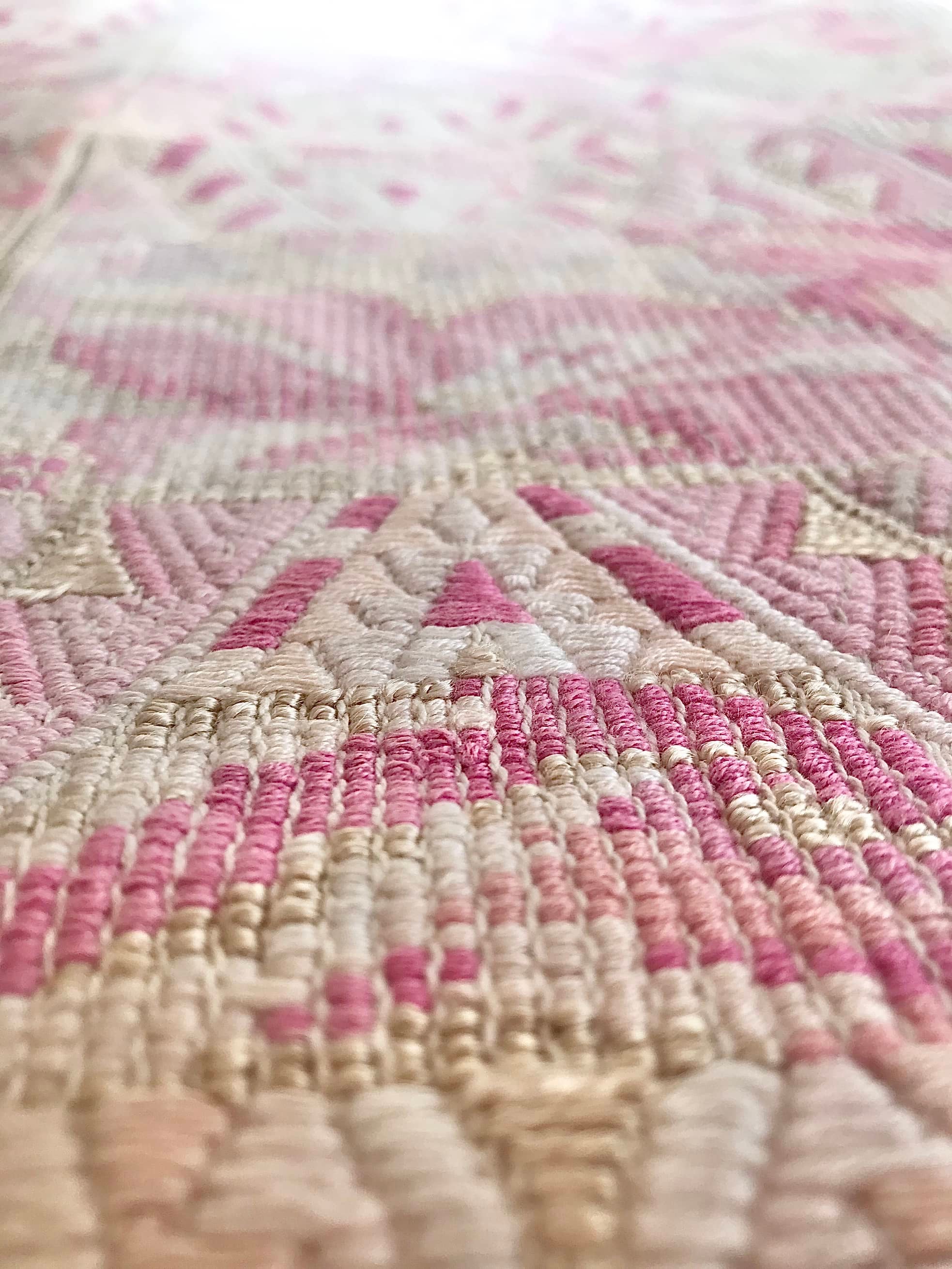 Guatemalan embroidered huipil pillow. Abstract flowers in a pale pink and white palette.