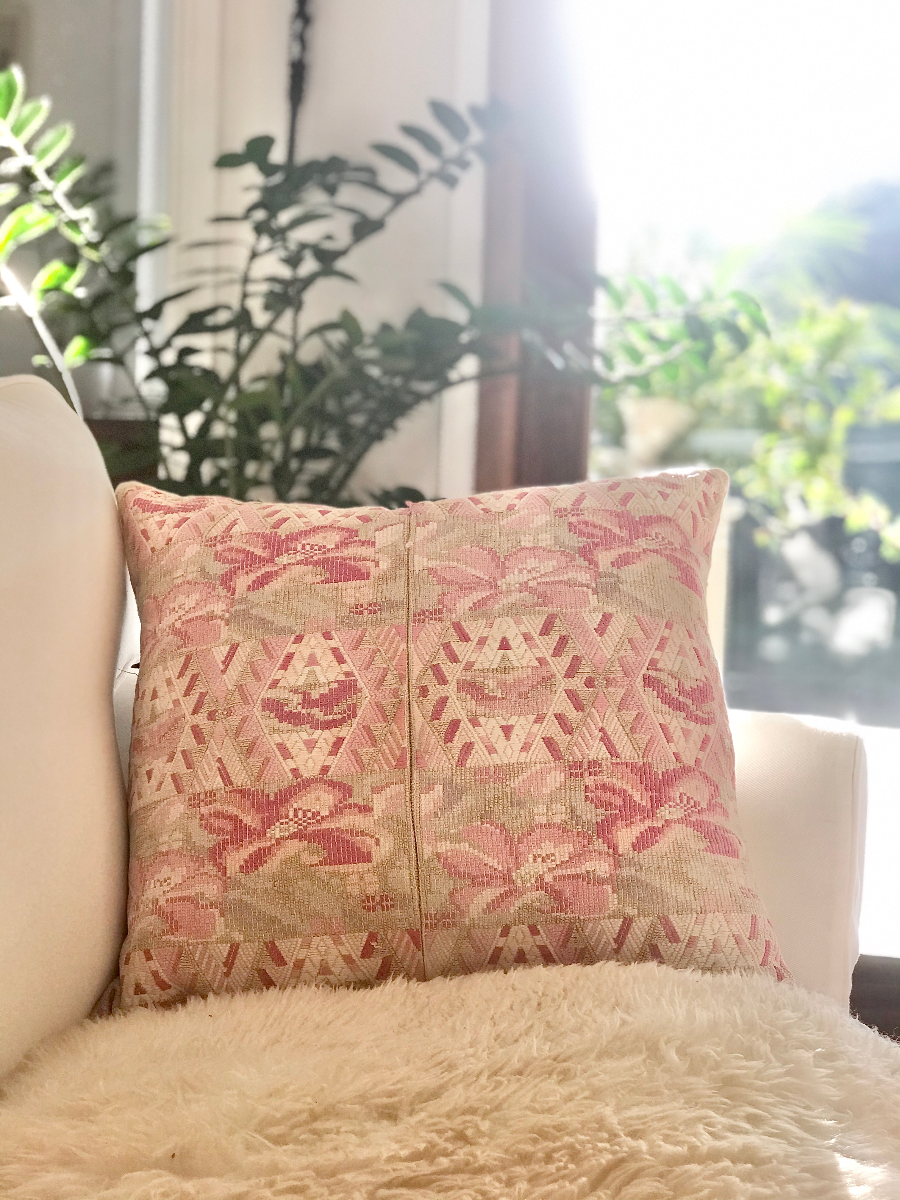 Guatemalan embroidered huipil pillow. Abstract flowers in a pale pink and white palette.
