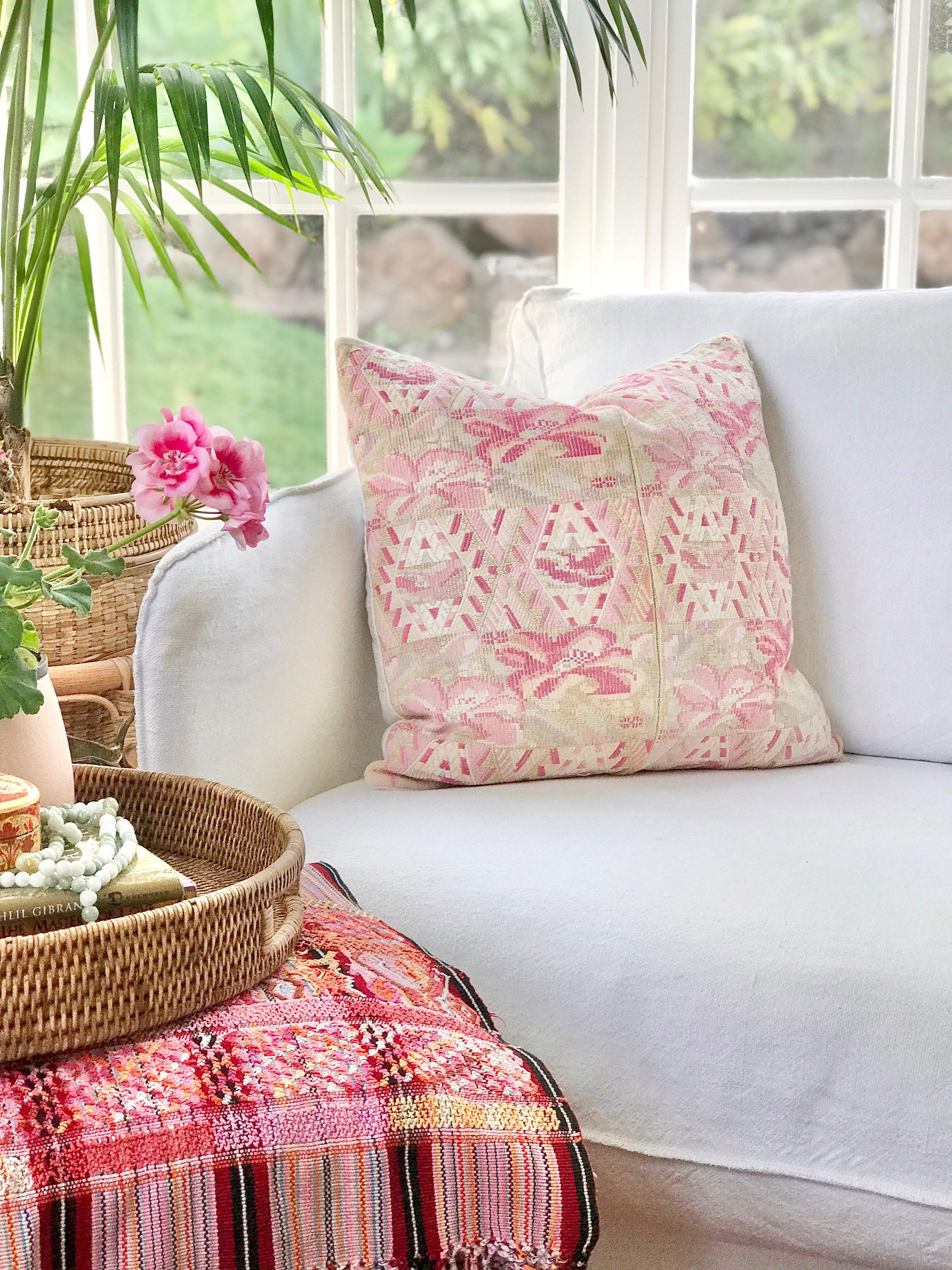 Guatemalan embroidered huipil pillow. Abstract flowers in a pale pink and white palette.
