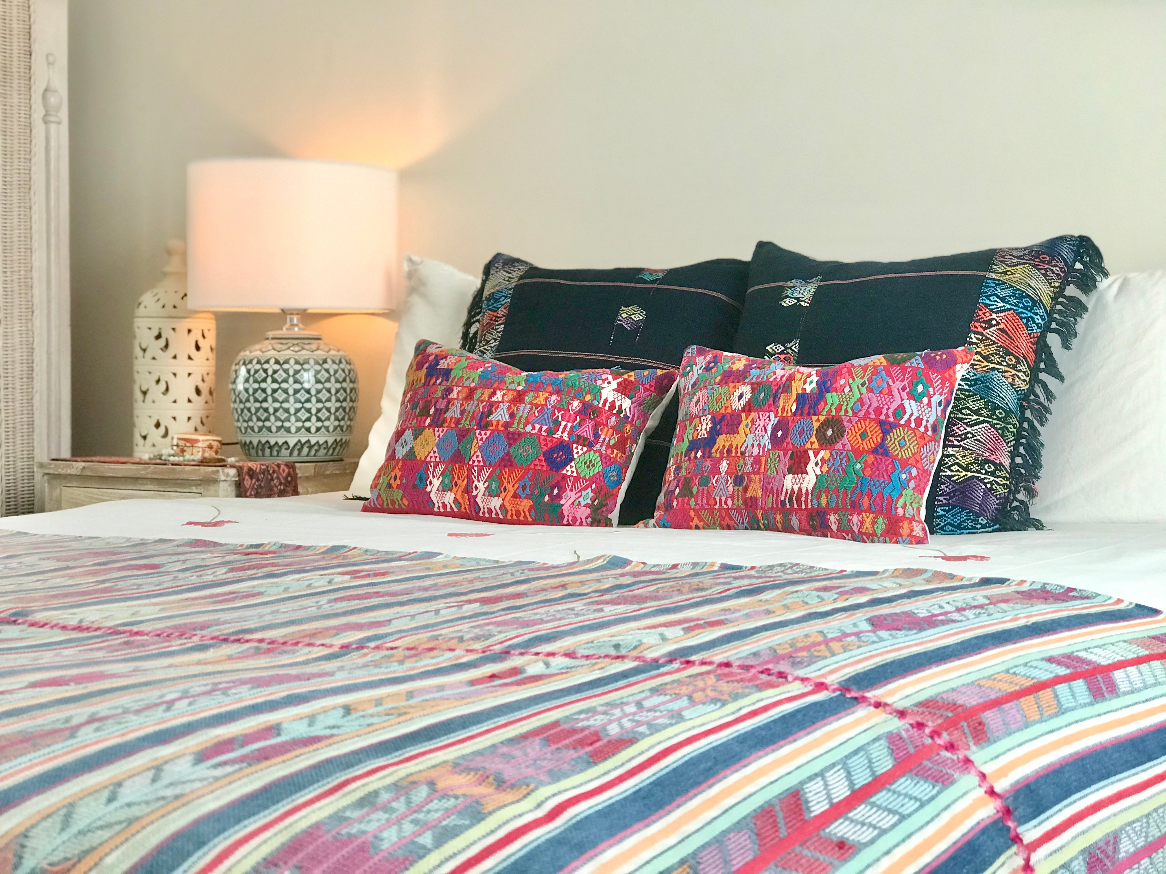 Guatemalan Huipil Pillow, vintage, hand embroidered Coban textile of brightly coloured tribal figures over a red cotton