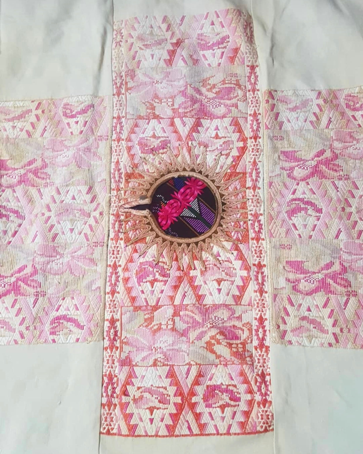 Guatemalan embroidered huipil pillow. Abstract flowers in a pale pink and white palette.