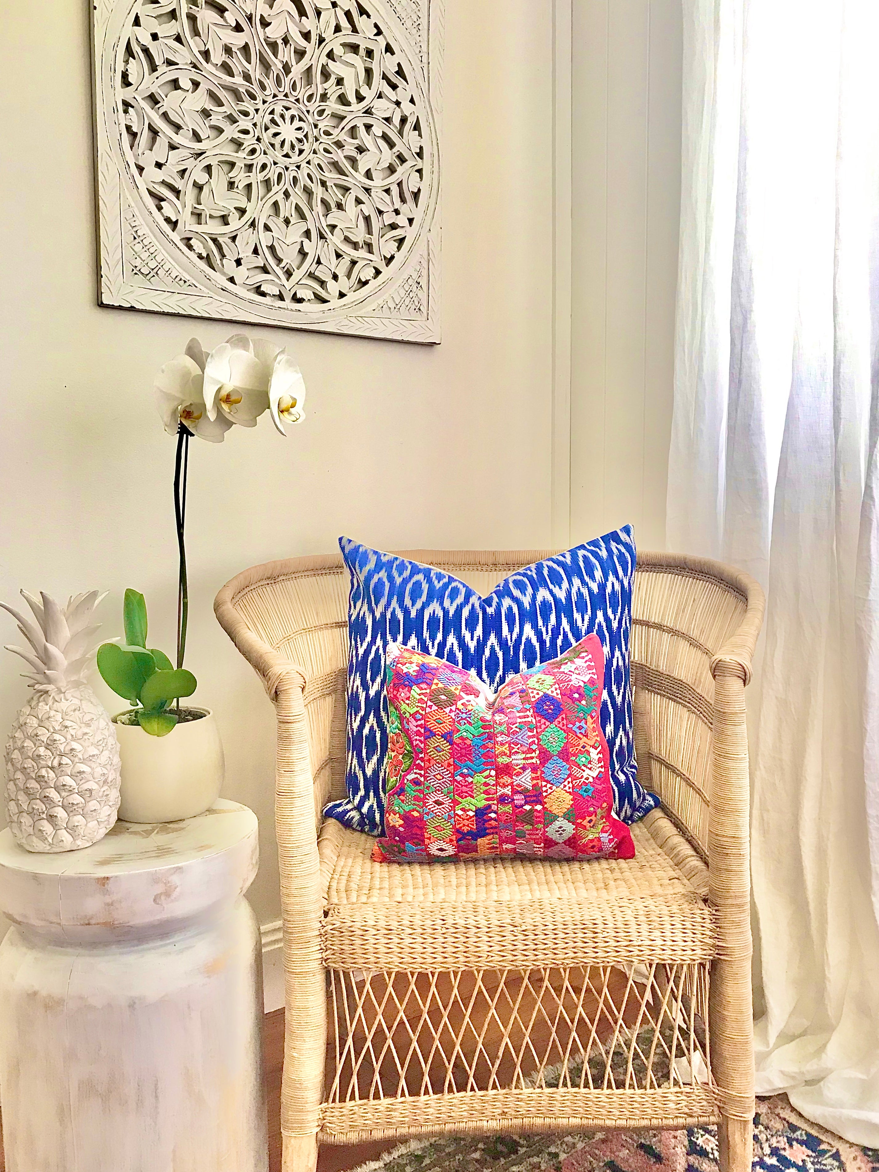 A pair of Guatemalan Huipil Pillows, vintage, hand embroidered Coban textile of brightly coloured tribal figures over a red cotton
