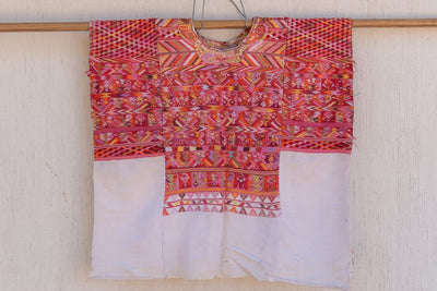 Red and pink San Juan Cotzal huipil for April