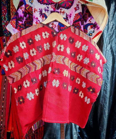 Red huipil with playful flowers