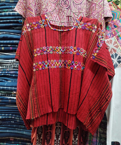 Red huipil with colorful embroidery