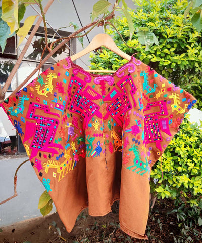 Brown and pink Chichi huipil with stylised animals
