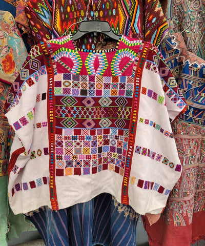 White Colotenango huipil with colorful motifs