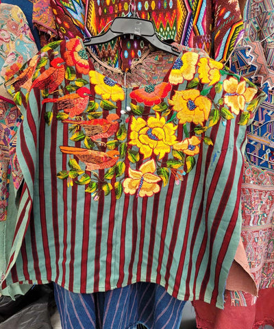 Flores naranjas y amarillas en el huipil de Santiago