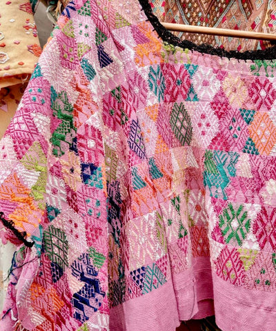 Colorful pink Coban huipil with black neckline
