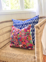 A pair of Guatemalan Huipil Pillows, vintage, hand embroidered Coban textile of brightly coloured tribal figures over a red cotton